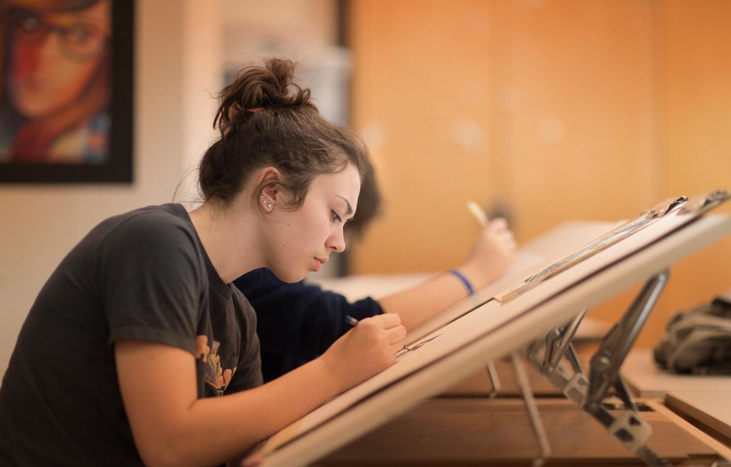 High school student sketching at a drafting table
