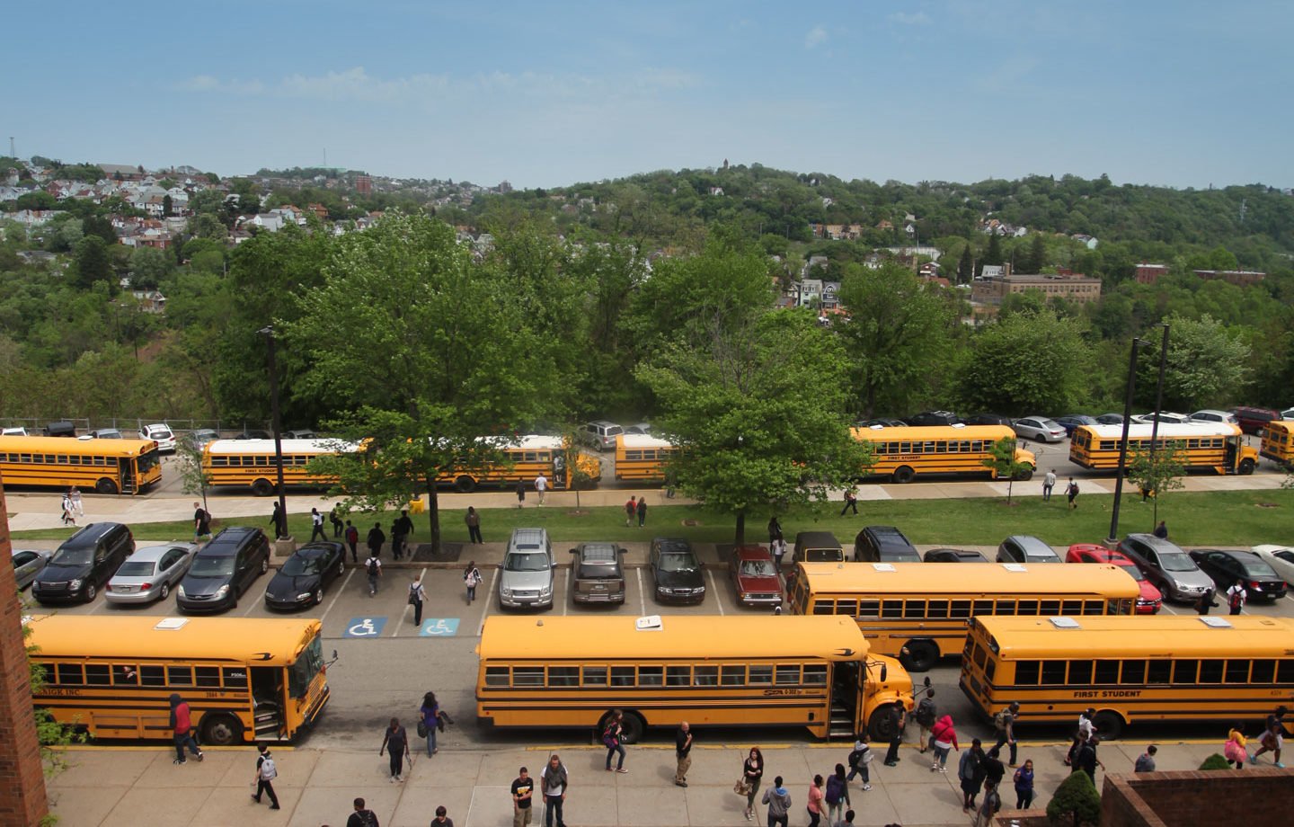 School children getting on buses at the end of a school day